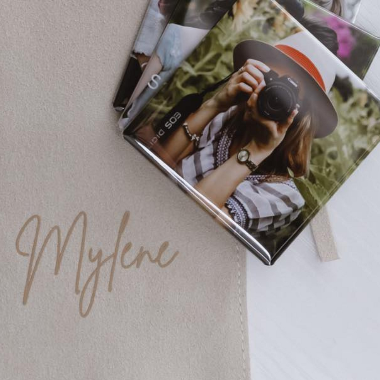 Personalized photo magnet with a cover featuring a person taking a photo, on a light surface.