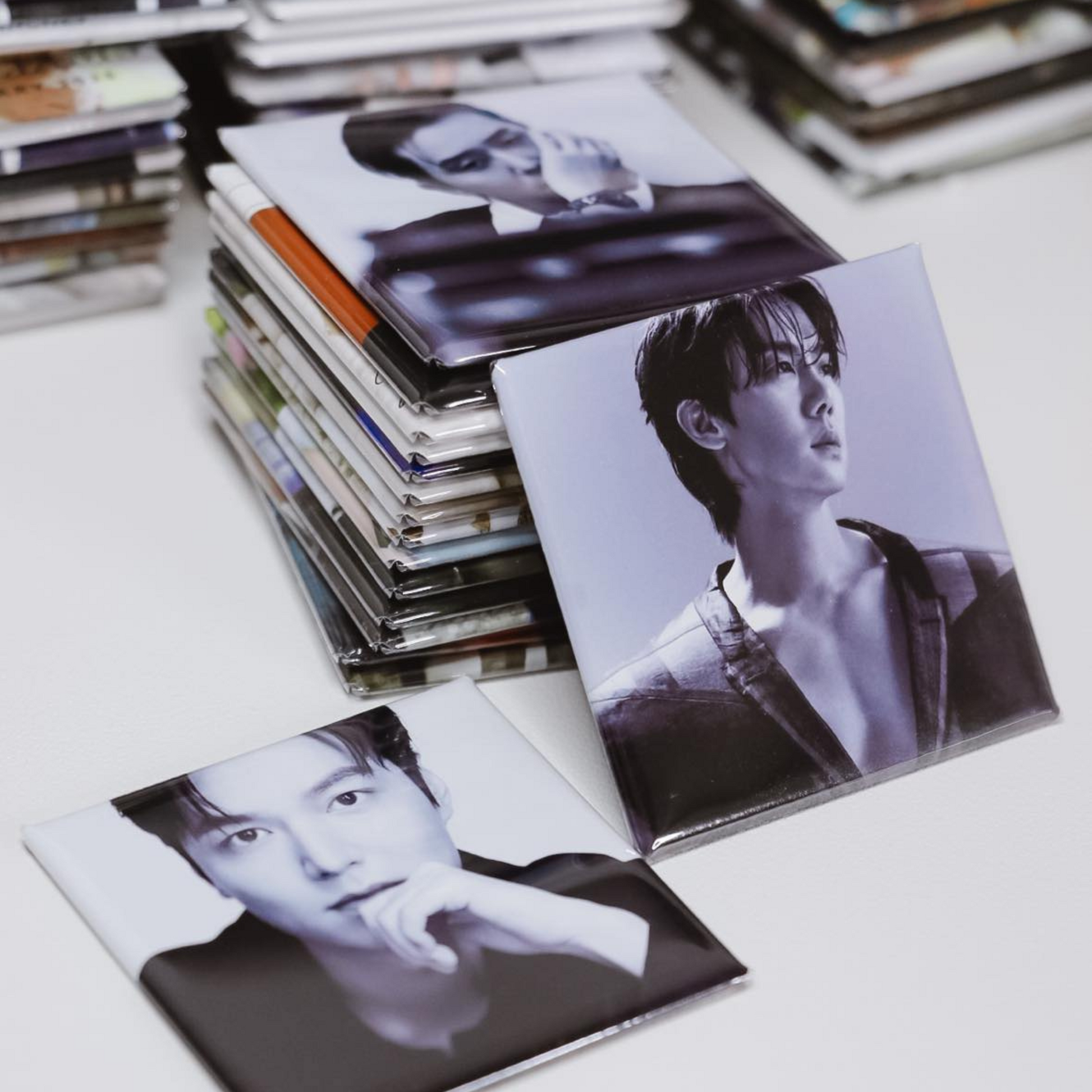 Stack of photo magnets with black and white images on a light surface