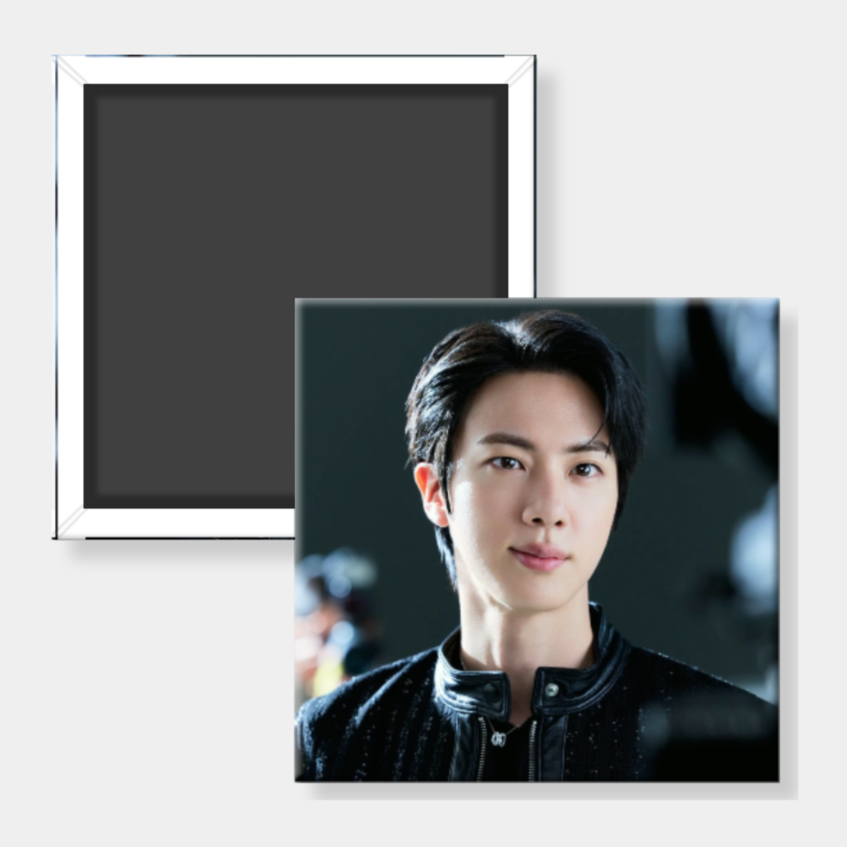 A square photo print or magnet featuring a portrait of a man in a dark outfit, shown in front of a second plain square with a white border on a light gray background.