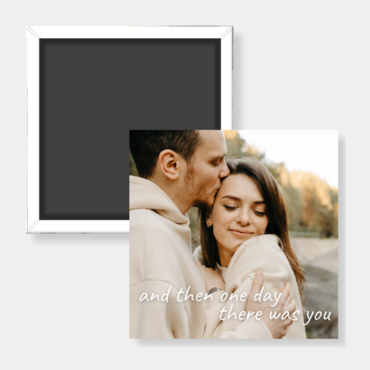 Photo magnet of a couple embracing with text 'and then one day there was you' on a white background.
