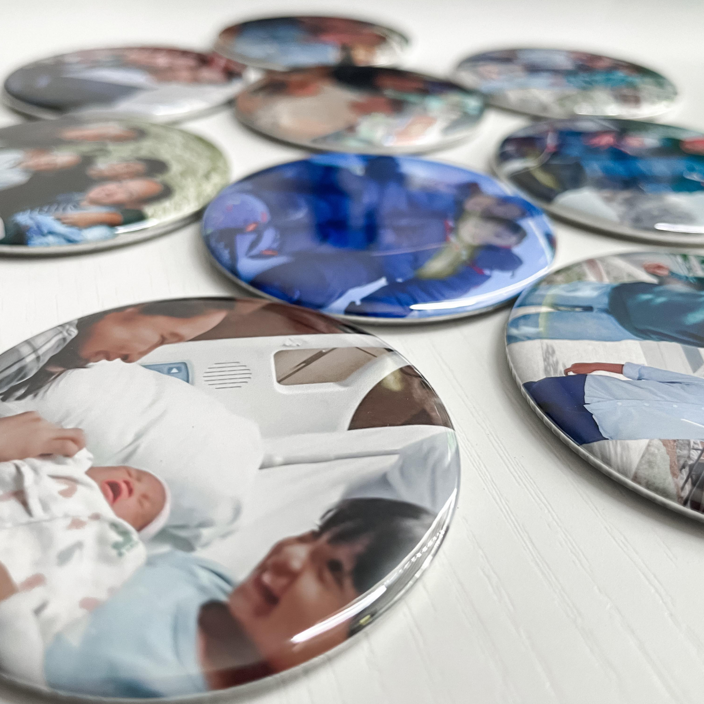 Collection of round photo magnets with various images on a white surface