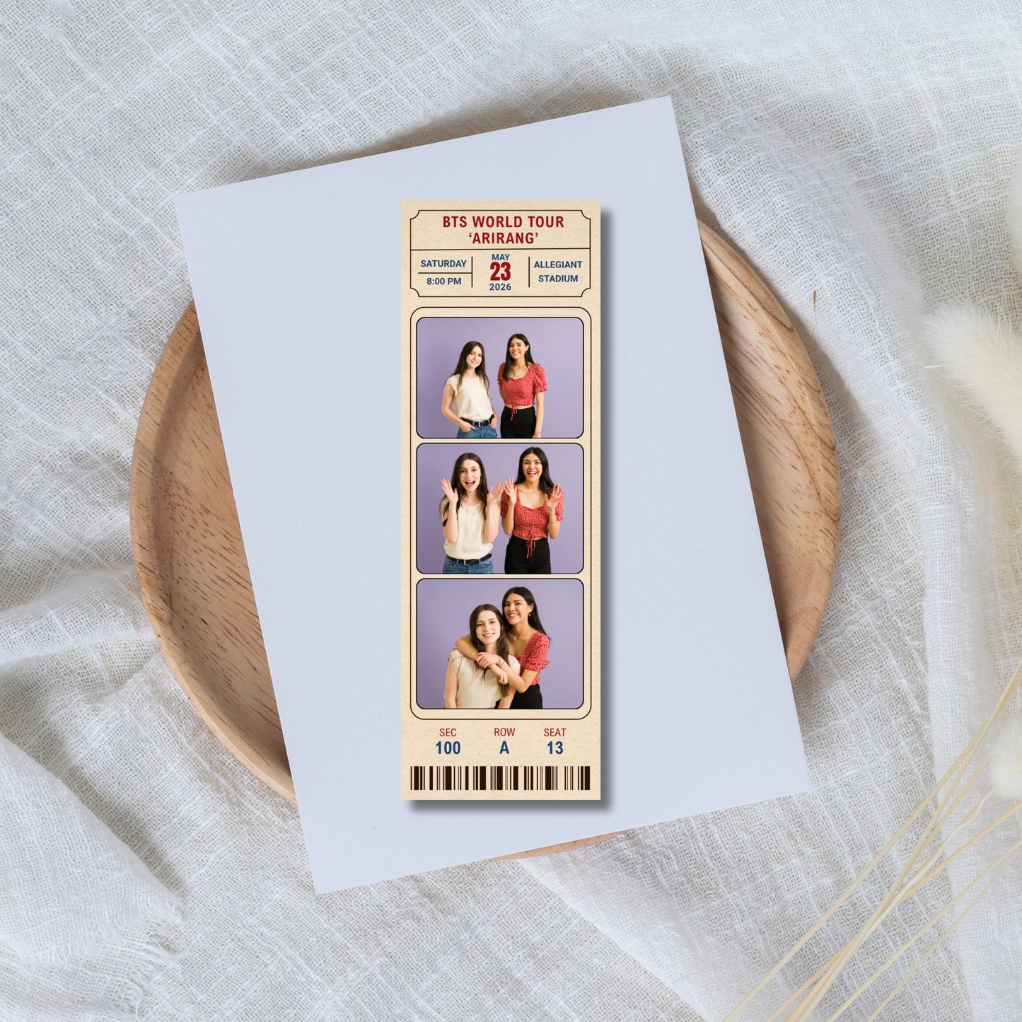 Memorabilia ticket with images of people on a white card, placed on a wooden plate.