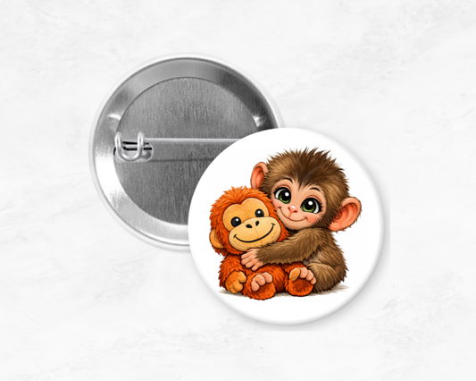 Button pin with illustration of a monkey hugging a teddy bear on a white background