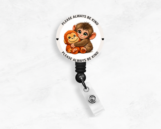 Retractable badge holder with cartoon monkeys and 'Please Always Be Kind' text on a white background